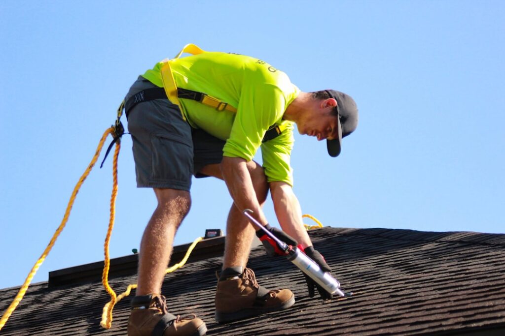 a-man-in-a-yellow-shirt-is-working-on-a-roof-efokg4zmibs